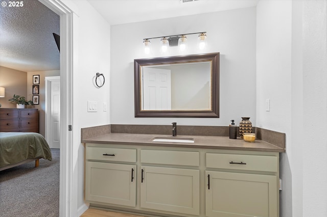 bathroom with vanity, a textured ceiling, and visible vents