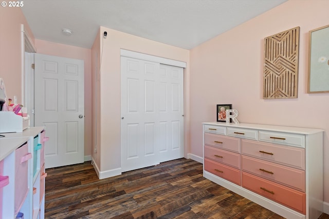 interior space featuring baseboards, dark wood-style floors, and a closet