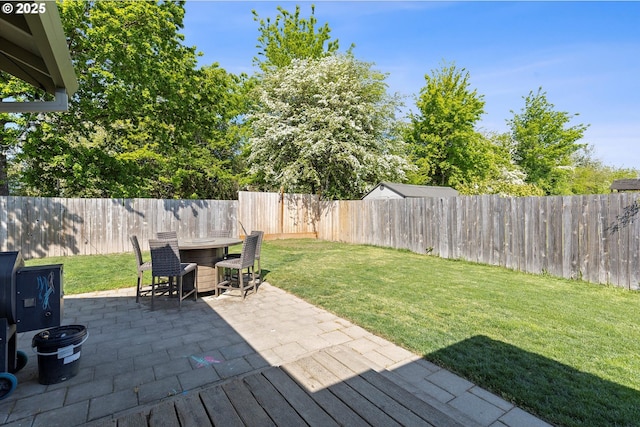 view of yard featuring a fenced backyard, a patio, and outdoor dining area