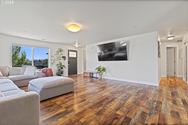 living area featuring baseboards, hardwood / wood-style flooring, and visible vents