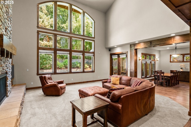 8585 NW Copeland St, Portland, OR 97229 - living area with a high ceiling, healthy amount of natural light, a fireplace, and baseboards