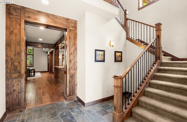 8585 NW Copeland St, Portland, OR 97229 - stairway with baseboards, stone finish floors, and recessed lighting