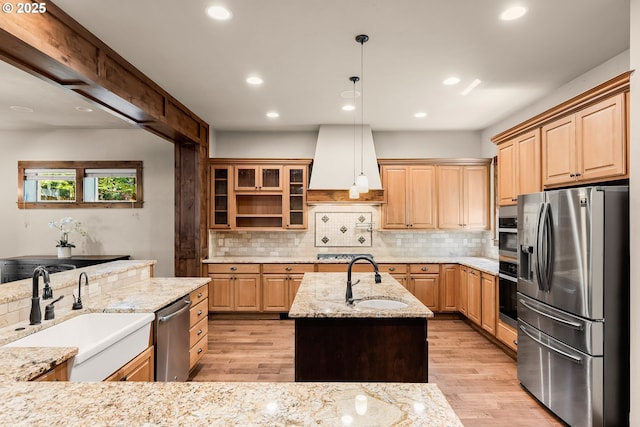 8585 NW Copeland St, Portland, OR 97229 - kitchen featuring appliances with stainless steel finishes, a sink, custom exhaust hood, light wood-type flooring, and recessed lighting
