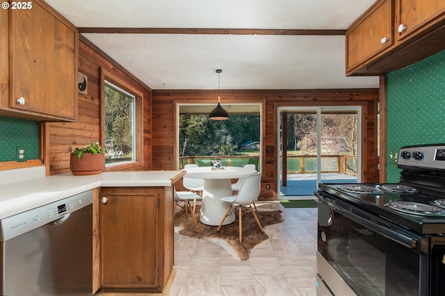 kitchen with light countertops, decorative light fixtures, brown cabinets, and stainless steel appliances