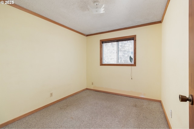 spare room with baseboards, a textured ceiling, crown molding, and carpet