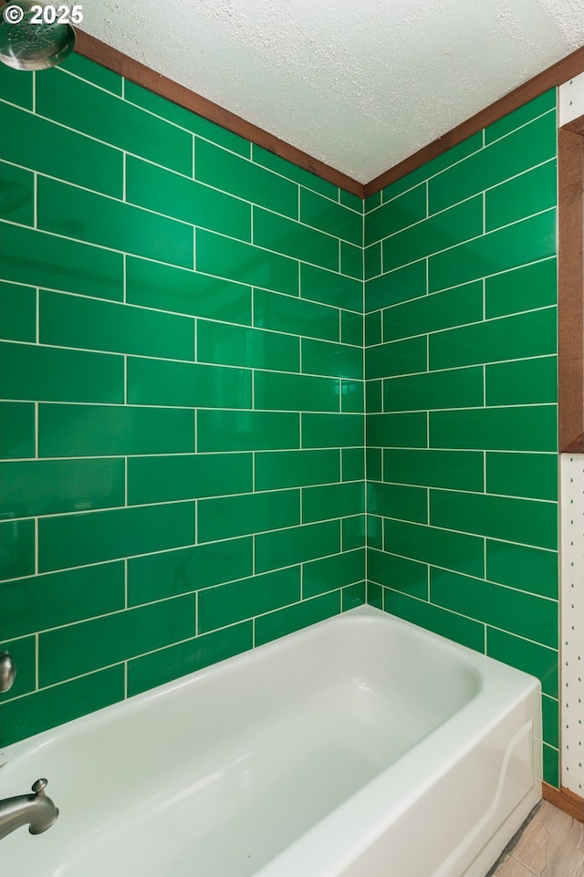 bathroom featuring a textured ceiling and bathing tub / shower combination