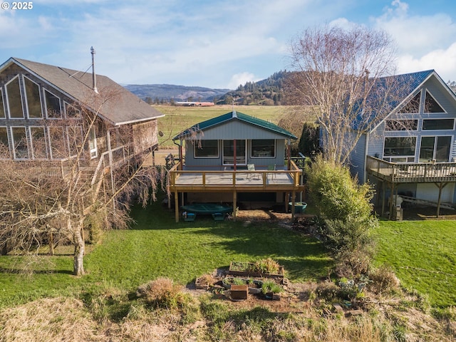 rear view of house featuring a lawn and a deck