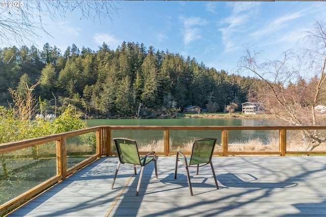 wooden deck with a water view and a view of trees