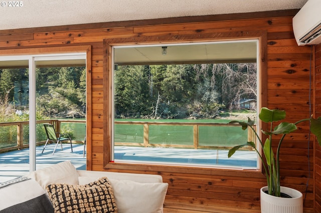 doorway to outside featuring a wall unit AC, wooden walls, and a textured ceiling