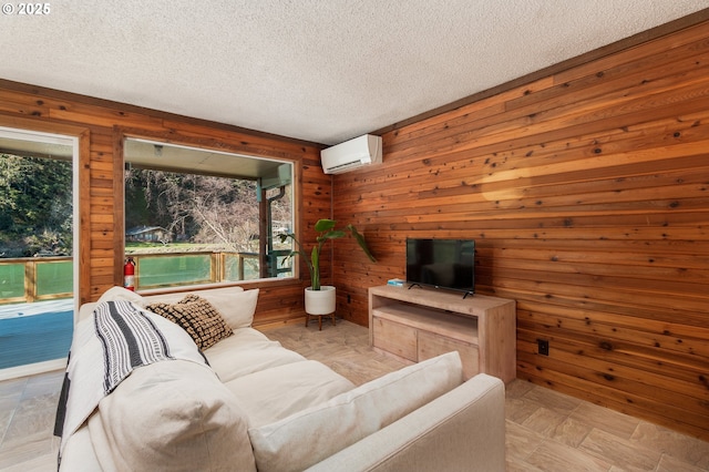 living room featuring a healthy amount of sunlight, a textured ceiling, and a wall mounted air conditioner