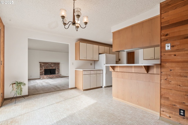 kitchen featuring pendant lighting, freestanding refrigerator, open floor plan, and light countertops