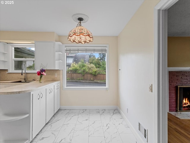 4501 NW Washington St, Vancouver, WA 98663 - kitchen with open shelves, a sink, light marble finish floors, and white cabinets
