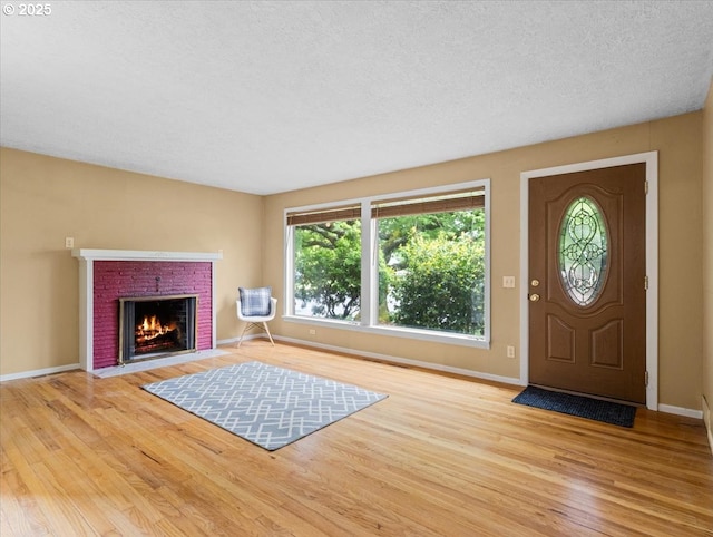 4501 NW Washington St, Vancouver, WA 98663 - foyer with wood finished floors, a brick fireplace, baseboards, and a textured ceiling