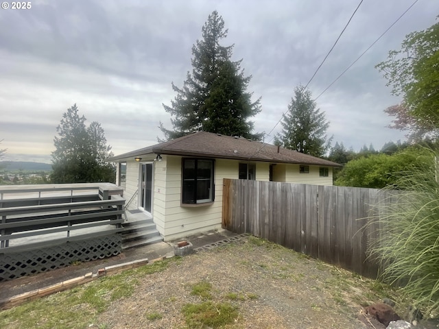 view of property exterior featuring fence and a deck