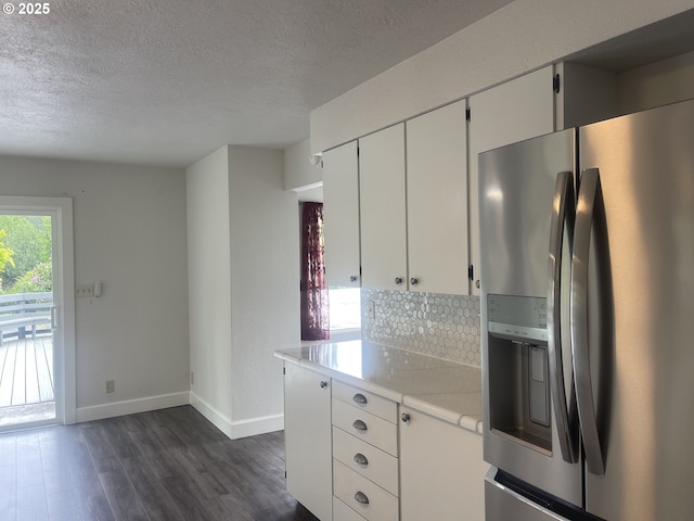 kitchen featuring stainless steel refrigerator with ice dispenser, baseboards, dark wood-style floors, light countertops, and a textured ceiling