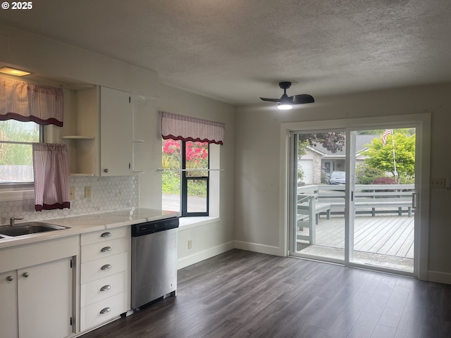 kitchen featuring stainless steel dishwasher, open shelves, tasteful backsplash, plenty of natural light, and a textured ceiling