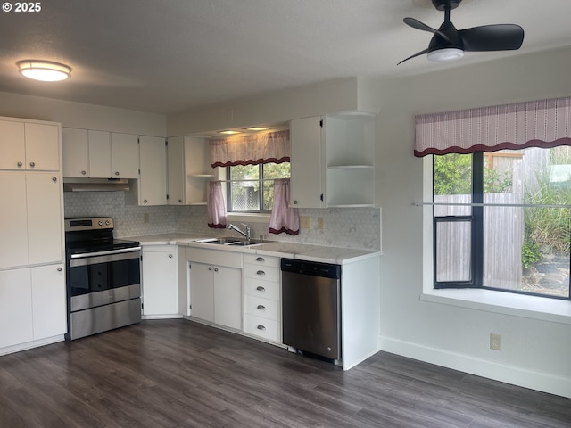 kitchen featuring stainless steel appliances, open shelves, a sink, under cabinet range hood, and tasteful backsplash