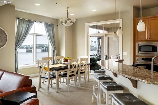 707 N Hayden Island Dr Unit 413, Portland, OR 97217 - dining room featuring an inviting chandelier, light carpet, a water view, and recessed lighting