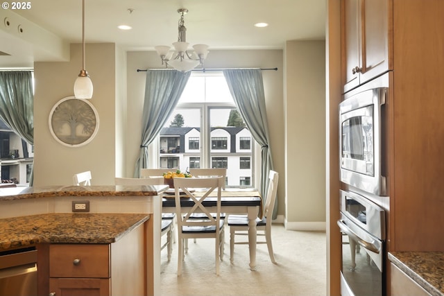 707 N Hayden Island Dr Unit 413, Portland, OR 97217 - kitchen with dark stone counters, light carpet, appliances with stainless steel finishes, and a chandelier