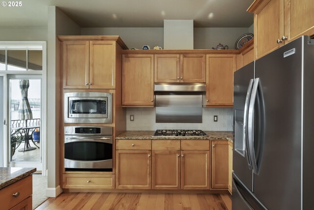 707 N Hayden Island Dr Unit 413, Portland, OR 97217 - kitchen with light wood finished floors, stainless steel appliances, stone countertops, and tasteful backsplash