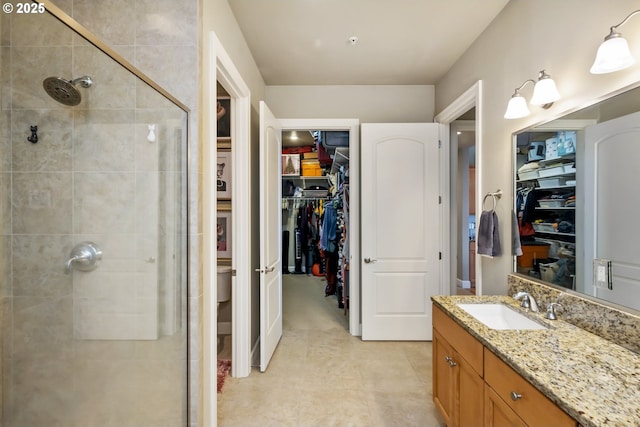 707 N Hayden Island Dr Unit 413, Portland, OR 97217 - bathroom featuring a walk in closet, vanity, tile patterned floors, and a stall shower