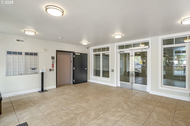 707 N Hayden Island Dr Unit 413, Portland, OR 97217 - empty room with visible vents, light tile patterned flooring, elevator, mail area, and baseboards