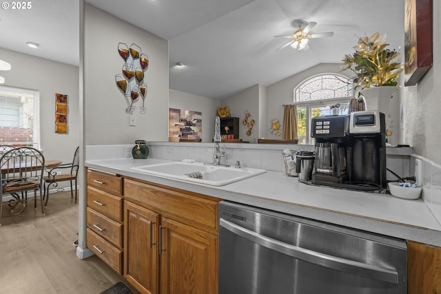 kitchen with lofted ceiling, sink, stainless steel dishwasher, ceiling fan, and light wood-type flooring