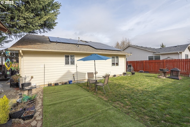 rear view of property featuring a yard, central air condition unit, and solar panels