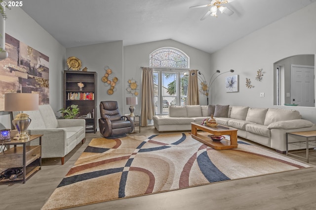 living room with vaulted ceiling, ceiling fan, and light wood-type flooring