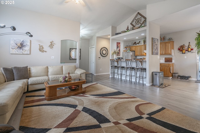 living room with high vaulted ceiling and light hardwood / wood-style flooring