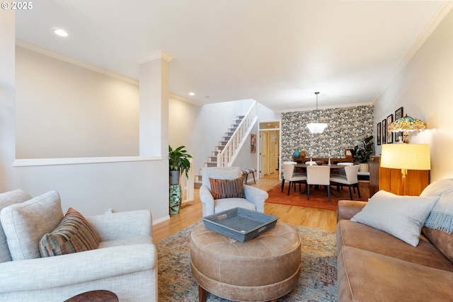 living room featuring light wood-style floors, recessed lighting, ornamental molding, and stairs