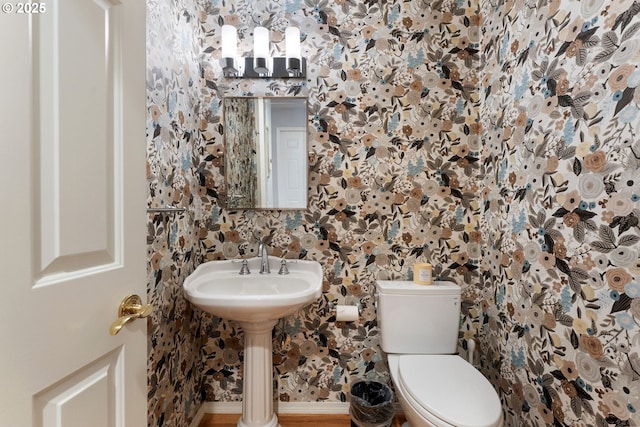 half bath featuring toilet and wallpapered walls