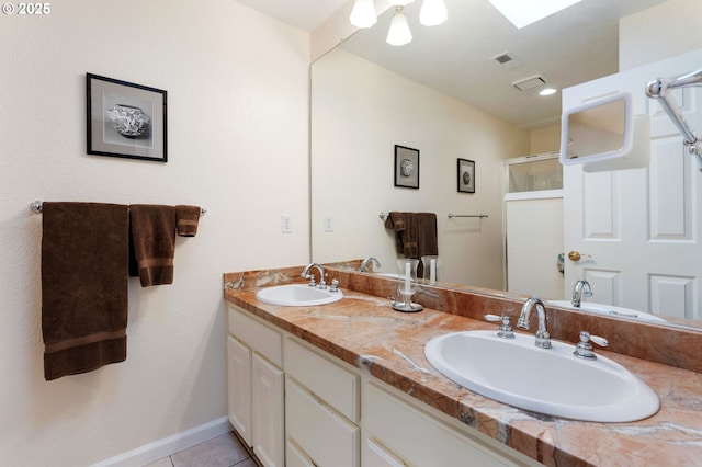 bathroom with tile patterned flooring, visible vents, a sink, and a shower stall