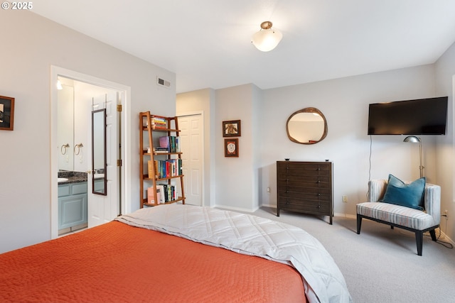 carpeted bedroom with baseboards, visible vents, and connected bathroom