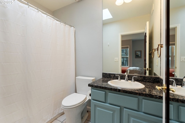 ensuite bathroom featuring a skylight, toilet, ensuite bath, tile patterned floors, and vanity