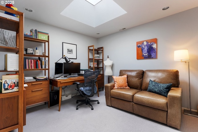 office space with a skylight, visible vents, and carpet