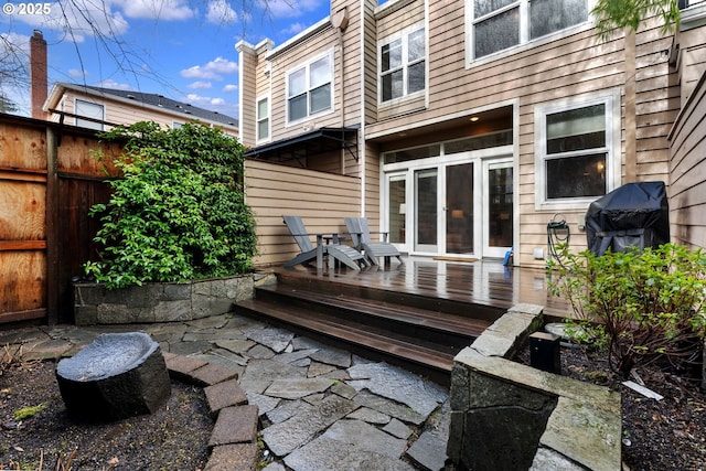 back of house featuring fence and a wooden deck