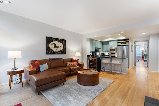 living area featuring light wood-type flooring, baseboards, and recessed lighting