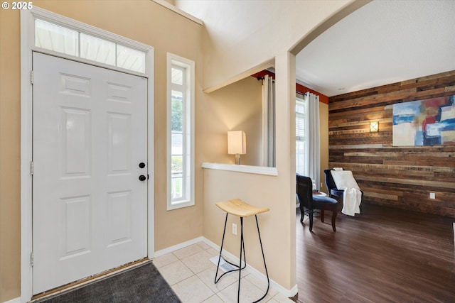 18211 NE 32nd St, Vancouver, WA 98682 - foyer featuring arched walkways, an accent wall, tile patterned flooring, wooden walls, and baseboards