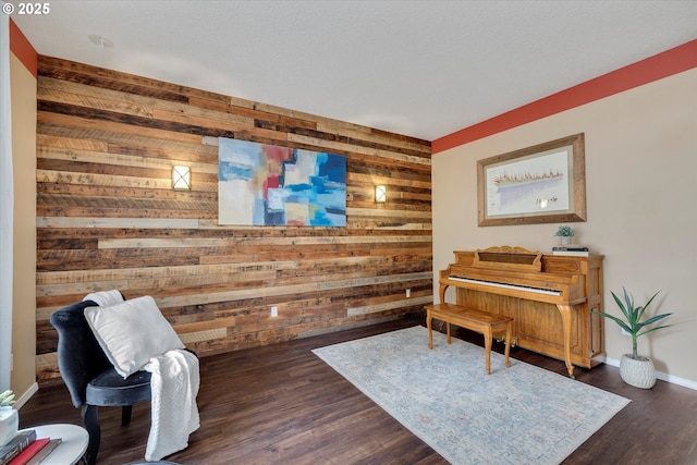 18211 NE 32nd St, Vancouver, WA 98682 - living area featuring an accent wall, wooden walls, baseboards, and dark wood finished floors