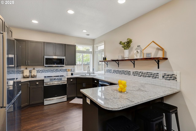 18211 NE 32nd St, Vancouver, WA 98682 - kitchen with a peninsula, open shelves, appliances with stainless steel finishes, a sink, and decorative backsplash