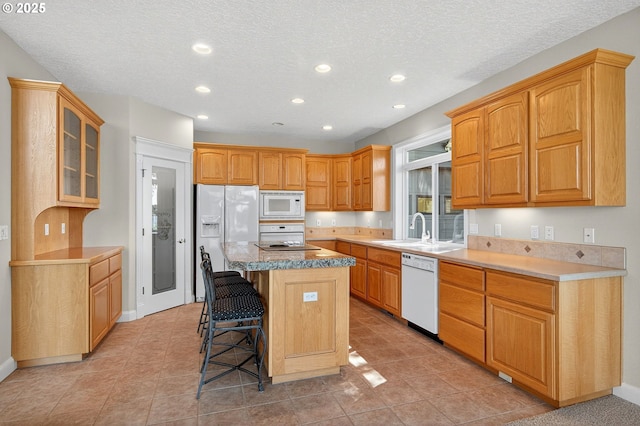 21401 NE Shore Dr, Fairview, OR 97024 - kitchen featuring white appliances, recessed lighting, a breakfast bar area, a center island, and glass insert cabinets
