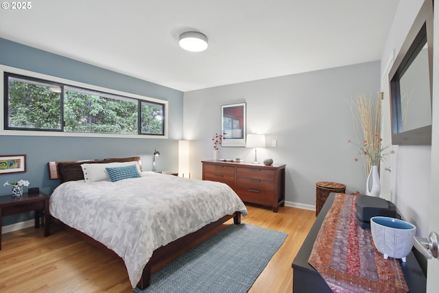bedroom with light wood-type flooring and baseboards