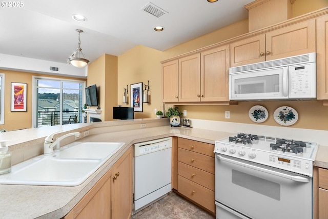 kitchen with light countertops, white appliances, light brown cabinets, and a sink