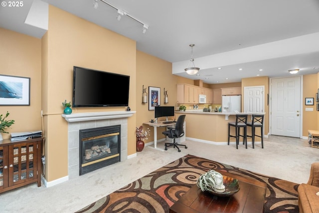 living area with baseboards, light colored carpet, a fireplace, track lighting, and recessed lighting