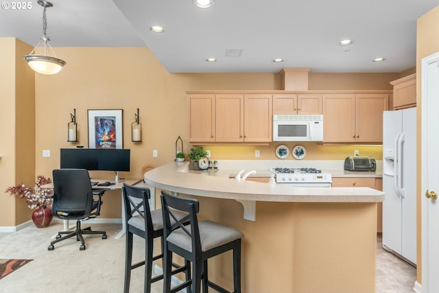 kitchen featuring light countertops, light brown cabinets, white appliances, a peninsula, and a kitchen bar