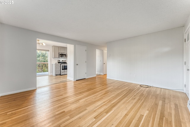 unfurnished living room with light hardwood / wood-style floors and a textured ceiling