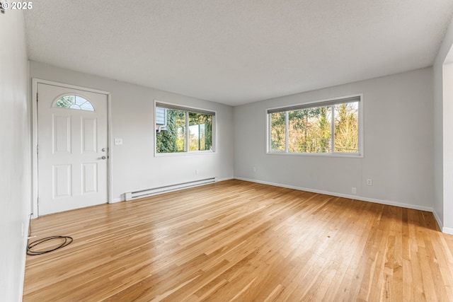 foyer with light hardwood / wood-style flooring and a baseboard heating unit