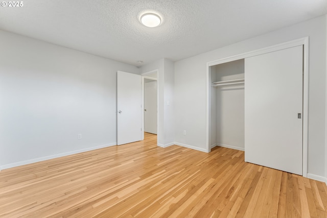 unfurnished bedroom with a closet, light hardwood / wood-style flooring, and a textured ceiling