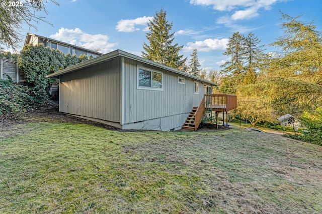 view of side of home with a wooden deck and a yard